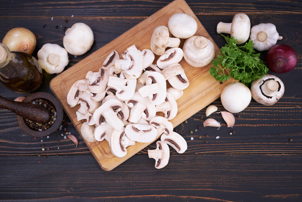 sliced raw champignon mushrooms on wooden cutting board. - Φωτογραφία, εικόνα