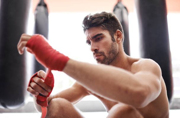 Kickboxing is his life. a handsome young kickboxer in the gym - Фото, изображение