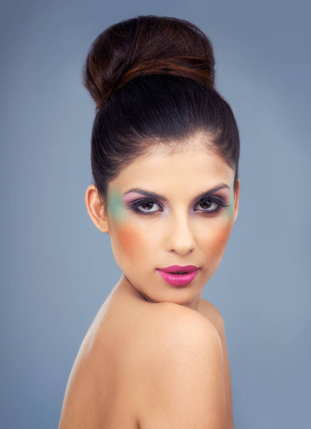 Colorful prima-donna. a beautiful young woman wearing bold makeup looking over her shoulder - Foto, immagini