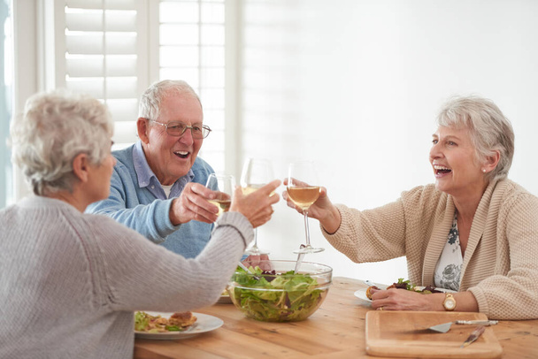 Το φαγητό είναι καλύτερο όταν το τρώμε μαζί. Ένας ηλικιωμένος άνδρας και δύο ηλικιωμένες γυναίκες απολαμβάνουν το γεύμα - Φωτογραφία, εικόνα