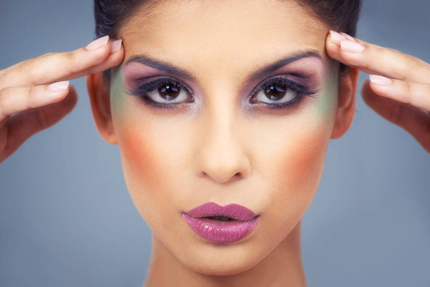 Avontuurlijke cosmetica. een mooie jonge vrouw bedekt met make-up - Foto, afbeelding