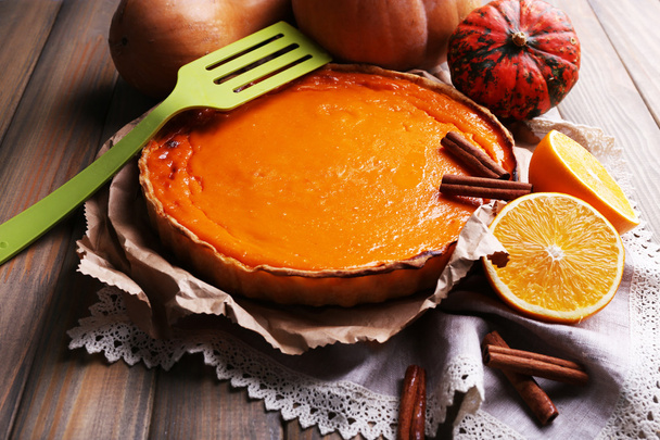 Homemade pumpkin pie on napkin, on wooden background - Foto, afbeelding