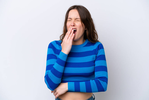Young caucasian woman isolated on white background yawning and covering wide open mouth with hand - Photo, Image