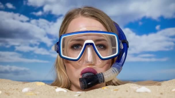 Una bella donna sepolta fino alla testa su una spiaggia con pallone da spiaggia accanto a lei - Filmati, video