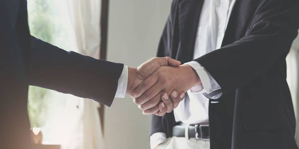 Dos hombres de negocios seguros estrechando manos durante una reunión en la oficina, el éxito, el trato, el saludo y el concepto de socio - Foto, imagen