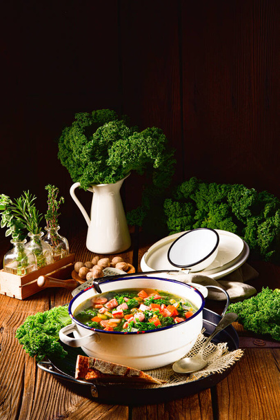 autumnal kale soup with sausage and bacon cubes - 写真・画像