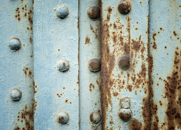 Старый окрашенный и ржавый фон с металлическими заклепками - Фото, изображение