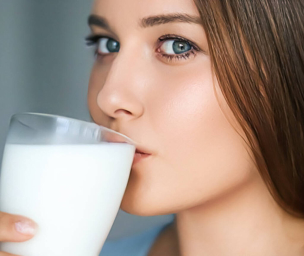 Диета и оздоровление, молодая женщина пьет молоко или коктейль протеиновый коктейль, портрет - Фото, изображение