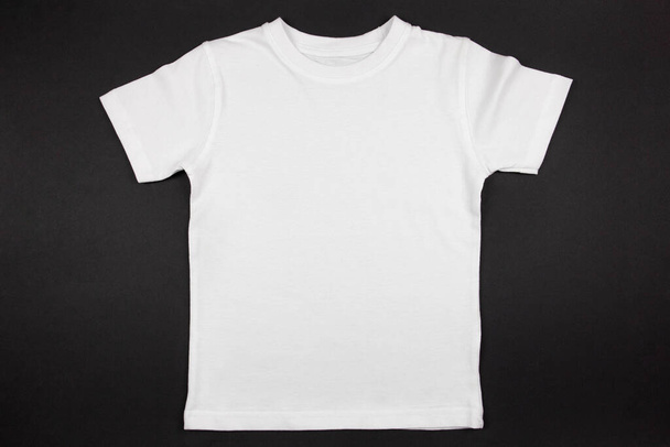 White womens cotton tshirt mockup on black background. Design t shirt template, print presentation mock up. Top view flat lay.  - 写真・画像
