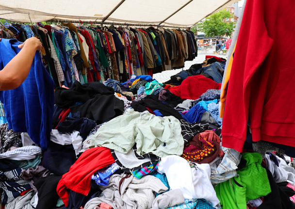 gebruikte kleding in de outdoor vlooienmarkt stal met veel koopjes - Foto, afbeelding
