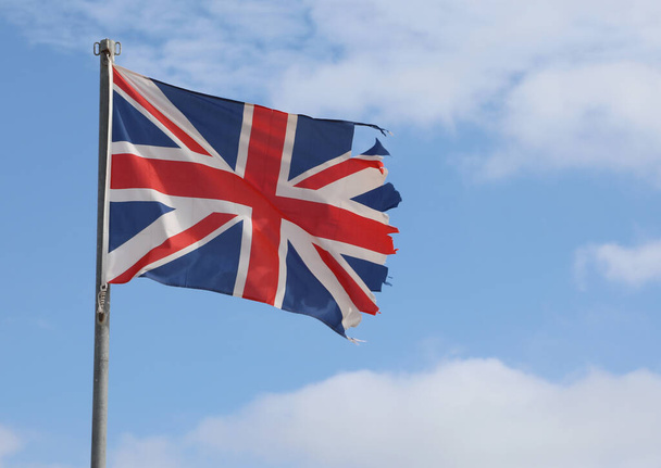 frayed English flag ruined due to bad weather - Foto, Imagem