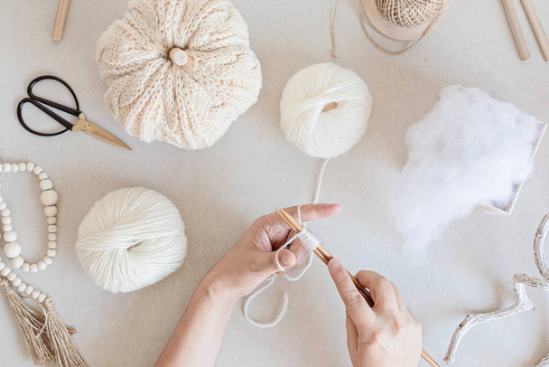 Hobby sfondo con zucche lavorate a mano a maglia, strumenti e accessori. Fai da te, decorazione artigianale per le vacanze autunnali e invernali. Posa piatta, vista dall'alto - Foto, immagini