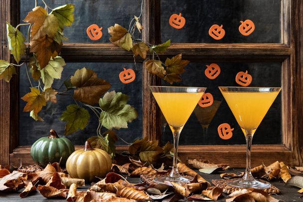 Cold drink seasonal autumn thanksgiving concept. Pumpkin fresh juice drink cocktail on   dark background  with fall decoration - Фото, зображення