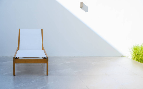 moderne Sonnenlounge mit weißer Wand im Freien. Sommerurlaub und Freizeit Lebensstil. Kopierraum - Foto, Bild