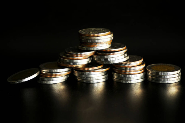 Stapel munten op zwarte achtergrond, Besparen geld concept - Foto, afbeelding