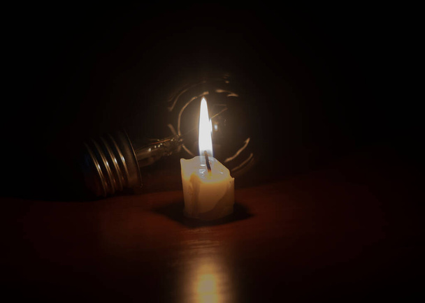 ampoule et bougie sur fond noir - Photo, image
