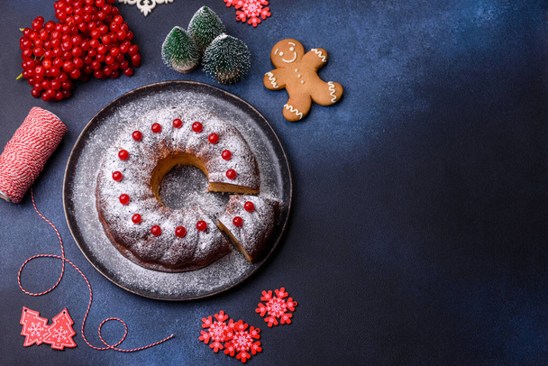 Homemade delicious round Christmas pie with red berries on a ceramic plate against a dark concrete background - Φωτογραφία, εικόνα