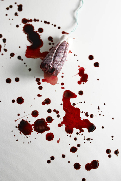 Tampone rosso usato nel sangue su sfondo bianco e insanguinato. Assistenza sanitaria, igiene, concetto femminile - Foto, immagini