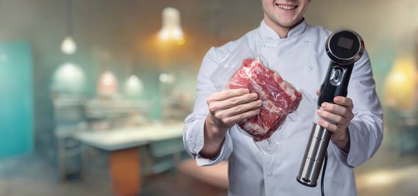 Повар показывает упакованное в вакуум мясо с устройством для приготовления пищи при низкой температуре. - Фото, изображение