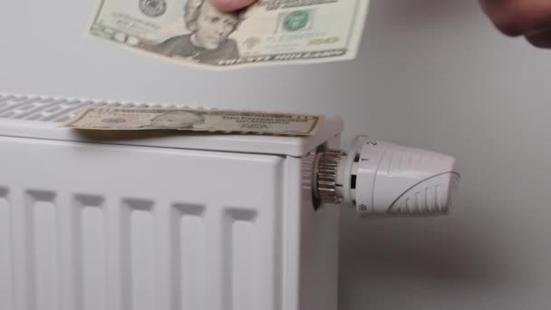 Counting dollar bills near heating radiator, Energy crisis concept, Rising costs in private households for gas bill due to inflation and war - Materiaali, video