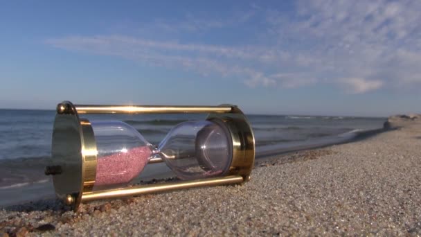 海のビーチで砂時計古代真鍮砂時計 - 映像、動画