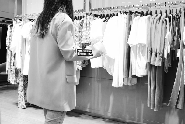 kobieta patrząc na ubrania i zakupy w centrum handlowym - Zdjęcie, obraz
