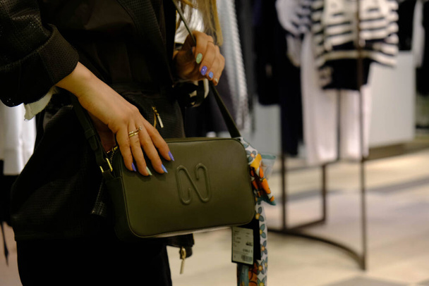 une femme portant un sac dans le magasin et tenant le sac dans ses mains - Photo, image