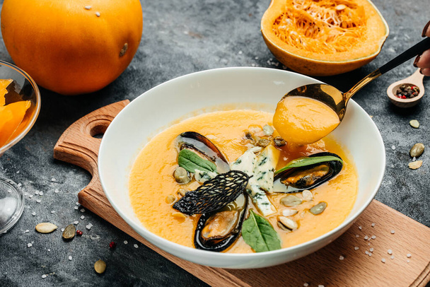 pumpkin puree soup with pumpkin seeds, seafood, mussels, shrimps, blue cheese, mold. Food recipe background. Close up. - Fotoğraf, Görsel