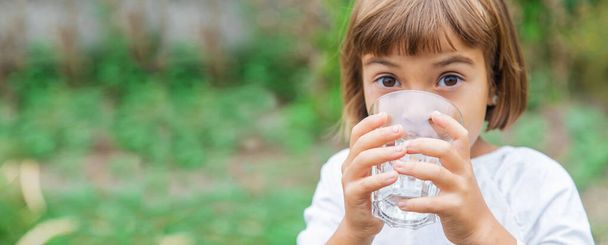 child drinks water from a glass. Selective focus. Kid. - Φωτογραφία, εικόνα