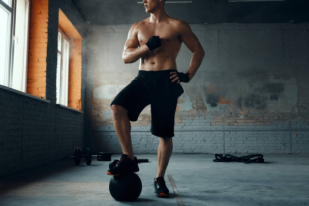 Unrecognizable young man preparing for workout in gym - Foto, afbeelding