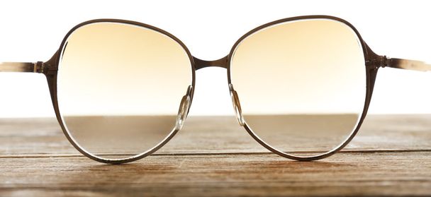 Eye glasses on wooden table on white background - Foto, Imagen