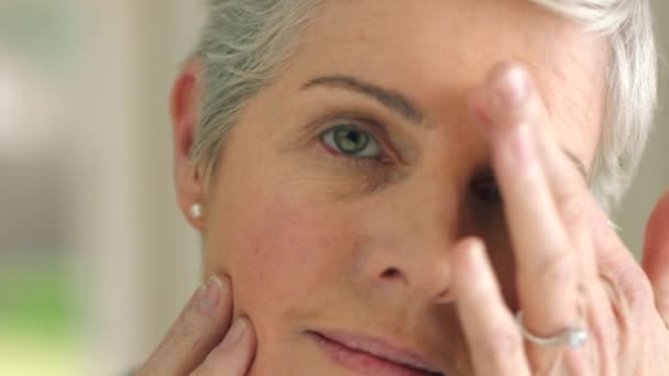 Beauty, face and anti aging with a senior woman touching her face and skin with her hand in a bathroom at home. Skincare, treatment and retirement with an attractive and elderly female pensioner. - Footage, Video