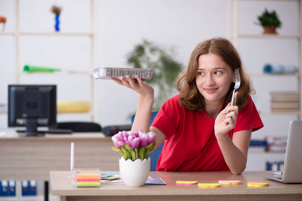 Diseñadora joven desayunando en el lugar de trabajo - Foto, imagen