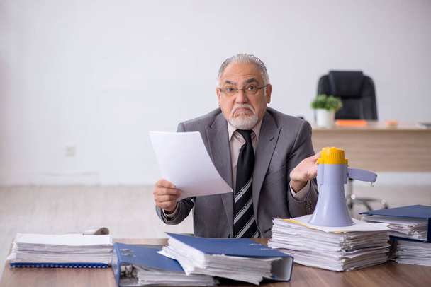 Starý muž šéf drží megafon na pracovišti - Fotografie, Obrázek