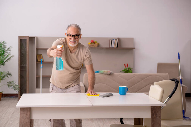 Älterer Mann erledigt Hausarbeit zu Hause - Foto, Bild