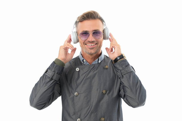 Happy businessman wearing headphones for music in studio isolated on white, music. Smiling guy listening to joyful music in headphones. - Photo, image