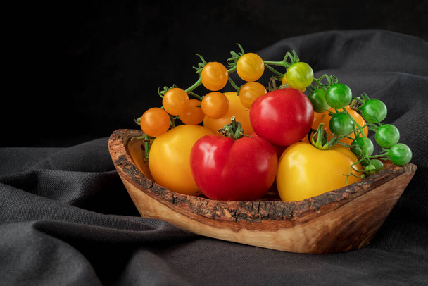 Branche de tomates jaunes sur fond de table, aliments sains  - Photo, image