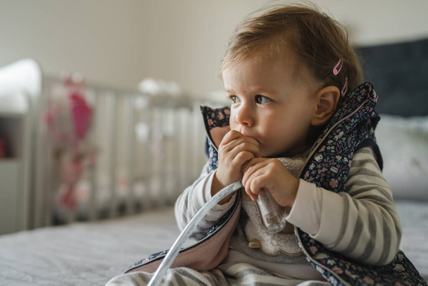 Une fille petit enfant caucasien tout-petit avec nez morve aspirateur nasal nettoyage nez sucer renifler pour libérer de l'espace de copie de respiration - Photo, image