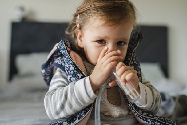 Yksi tyttö pieni valkoihoinen lapsi lapsi lapsi kanssa nenä räkä imee nenän aspiraattori puhdistus nenä imeä vasikka vapauttaa hengitys kopioi tilaa - Valokuva, kuva
