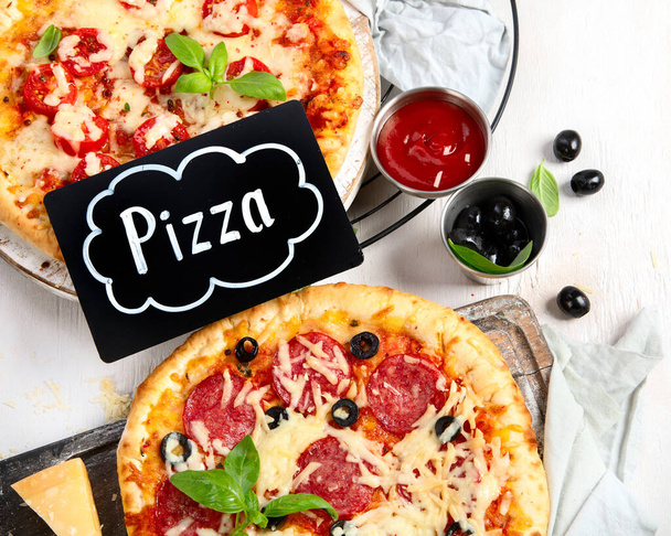 Freshly baked pizza on dark background. Tasty homemade food concept. Top view - Фото, зображення