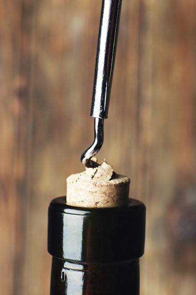 Bottle opener close-up, on wooden background - Fotó, kép