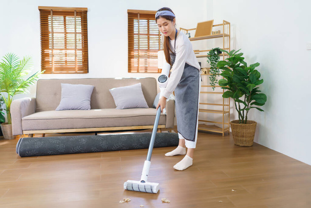 Hygiena čištění koncept, Pokojská používat mop k čištění a čištění prachu na podlaze v obývacím pokoji. - Fotografie, Obrázek