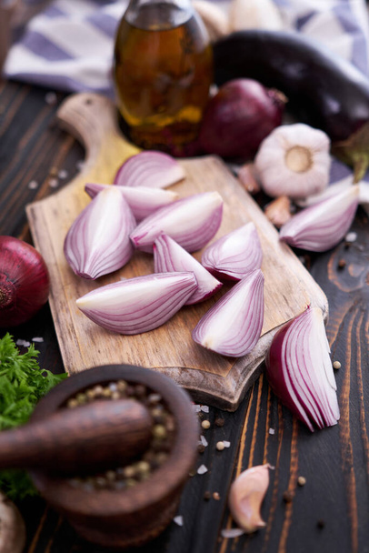 Red Onion on wooden cutting board with dark background. - Foto, Imagem