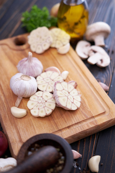 Garlic on wooden chopping board on wooden background or table. - Фото, зображення