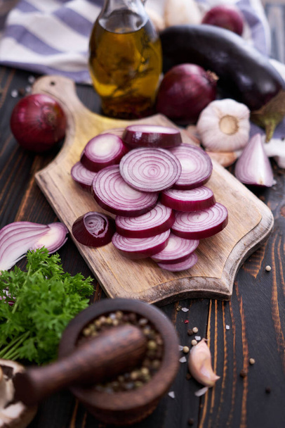 Red Onion on wooden cutting board with dark background. - Φωτογραφία, εικόνα