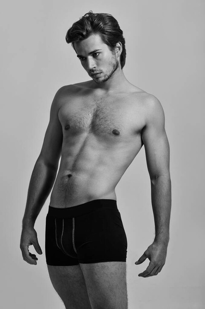 Beautiful masculinity. Studio shot of a handsome young man posing in his underwear- monochrome - Foto, imagen