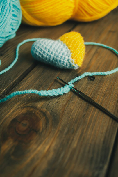 Patriotic heart - yellow-blue crocheted. crochet two-tone heart. yarn heart. heart on a wooden table. - Photo, Image