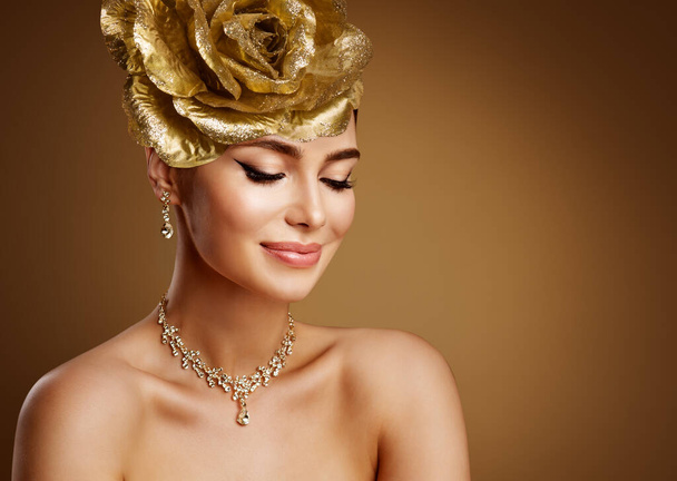 Beautiful Woman in Golden Wedding Jewelry Set. Beauty Model in Gold Tiara and Necklace. Fashion Girl Face Portrait with Perfect Bride Make up over Brown background - Fotoğraf, Görsel