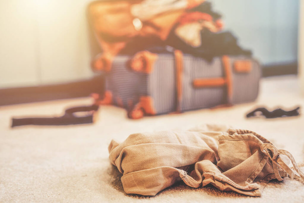 Open suitcase full of clothes in room - Foto, Bild
