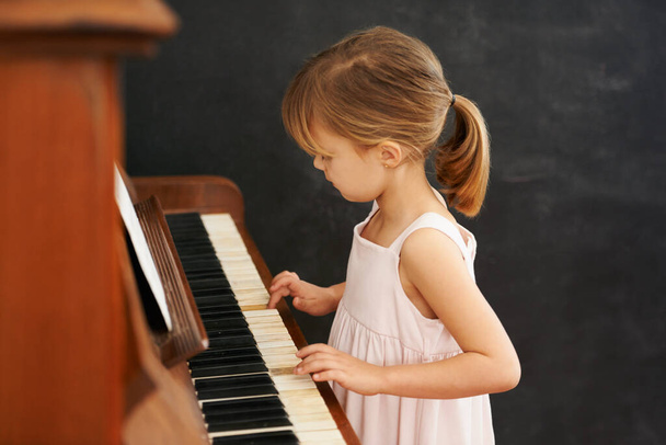 Gyakorlok az előadásra. Egy kislány zongorázik. - Fotó, kép